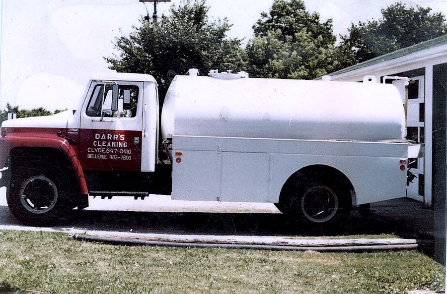 A red and white Darr’s Cleaning tanker with both phone numbers on the door