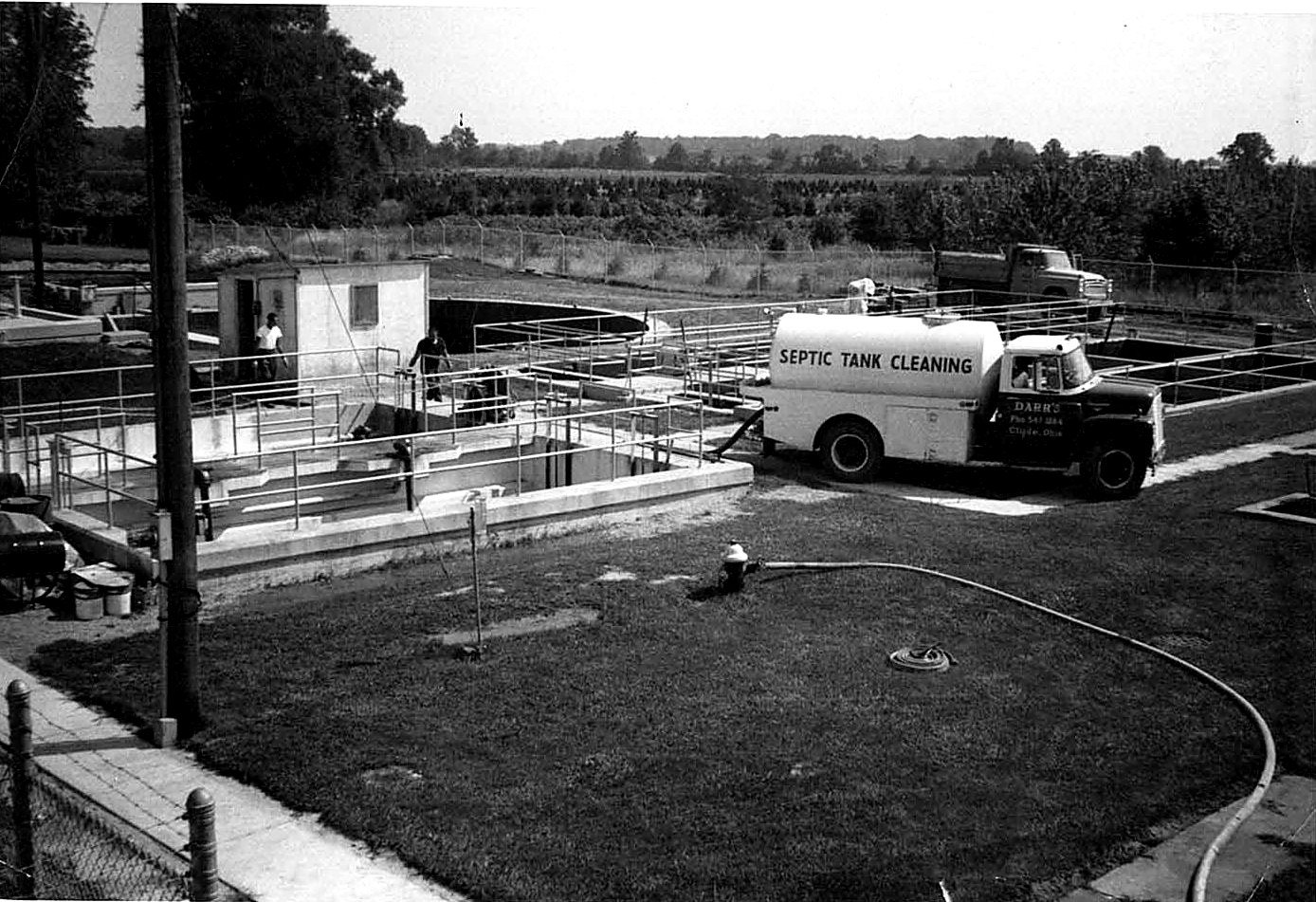 A Darr's Cleaning, Inc. tanker lettered Septic Tank Cleaning working at a treatment plant in the early years