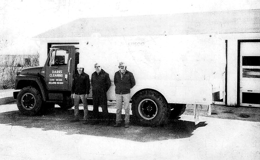 Three Darr's crew members standing beside a box truck at the yard