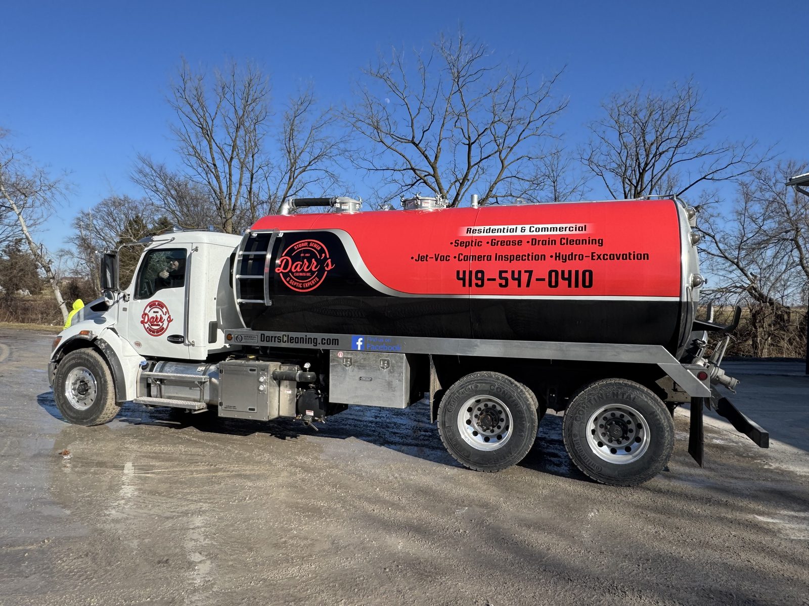 A Darr's Cleaning vacuum tanker in the company's red and black livery, lettered with its services and phone number